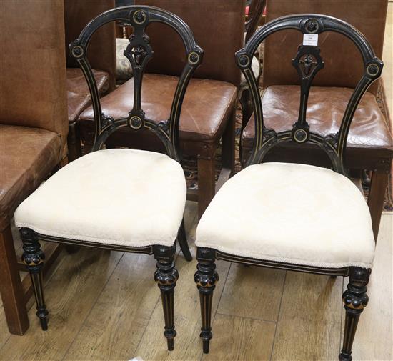 A pair of ebonised dining chairs